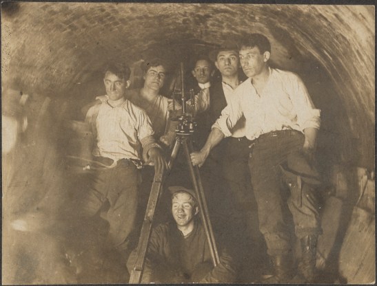 Engineers in tunnel during construction of present IRT at City Hall Station.