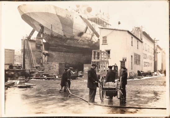 Morse Dry Dock and Repair Company. Employees Association of Morse Dry Dock and Repair Co. [Fire hose drill.]. 1919. Museum of the City of New York.  F2013.130.2